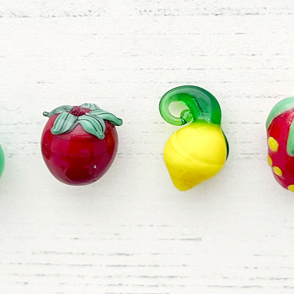 Fruit glass bead range including a raspberry glass bead, pear glass bead, tomato glass bead, lemon glass pendant, strawberry glass bead and a orange shaped glass bead