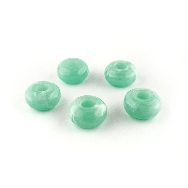 Five mint green translucent round beads with a central hole, arranged on a plain white background.