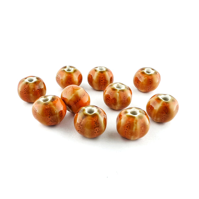 Ten round ceramic beads with a glossy amber-brown body and speckled texture, arranged on a white background.
