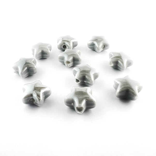 Ten small star-shaped ceramic beads with a glossy gray and white marbled pattern, arranged on a plain white background.