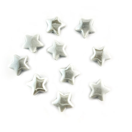 Ten small glossy star-shaped ceramic beads in a light gray color, arranged on a plain white background.