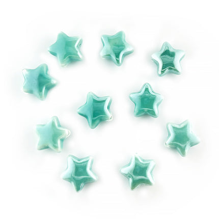 Ten small glossy star-shaped ceramic beads in a light mint green or aqua color, arranged on a plain white background.