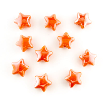 Ten glossy orange star-shaped beads arranged on a plain white background.