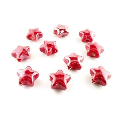 Ten glossy red ceramic star-shaped beads with a lustre finish, arranged on a plain white background.