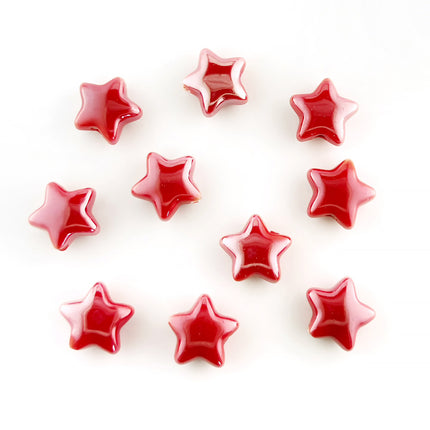 Ten glossy red ceramic star-shaped beads arranged on a plain white background.