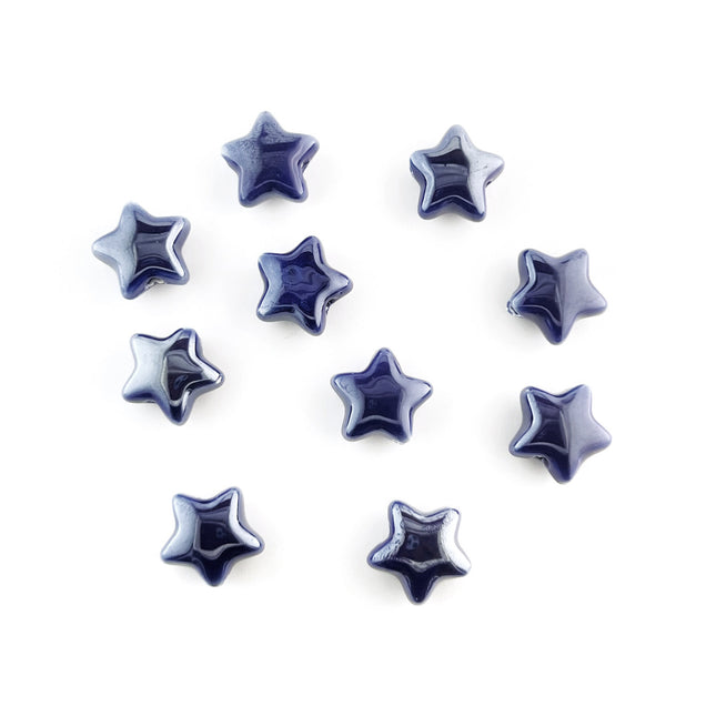 Ten glossy, five-pointed star-shaped ceramic beads in a deep navy blue color, arranged on a plain white background.