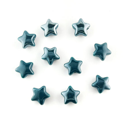 Ten glossy dark teal ceramic star-shaped beads arranged on a plain white background.