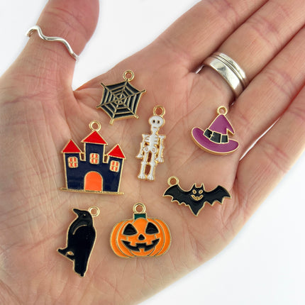 enamelled gold plated halloween range of charms including a black bird, haunted house, skeleton, witch's hat, bat and of course a pumpkin
