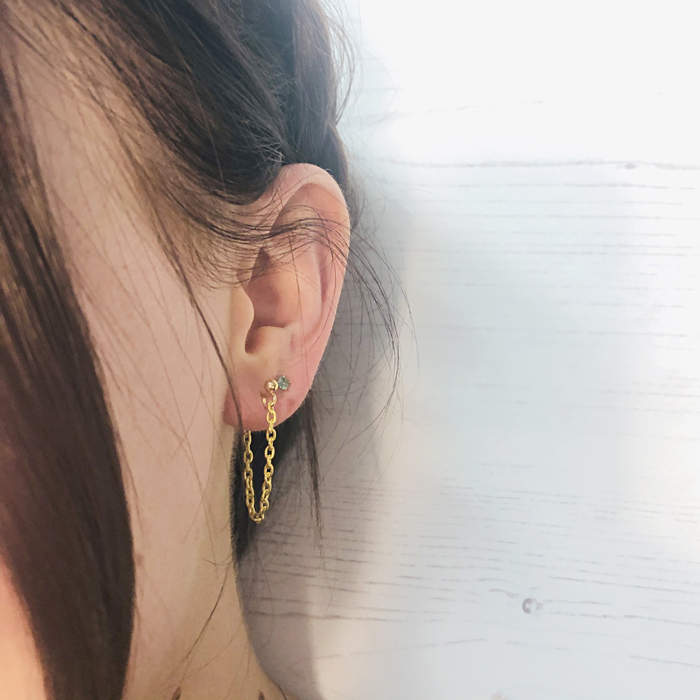 The earring loop hangs from the front to the back of the ear lobe.